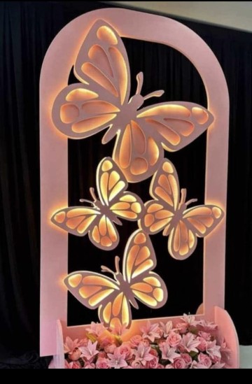 Luxury Punjabi wedding stage decoration featuring ivory flowers, golden backdrop panels, crystal chandeliers, and warm lighting.