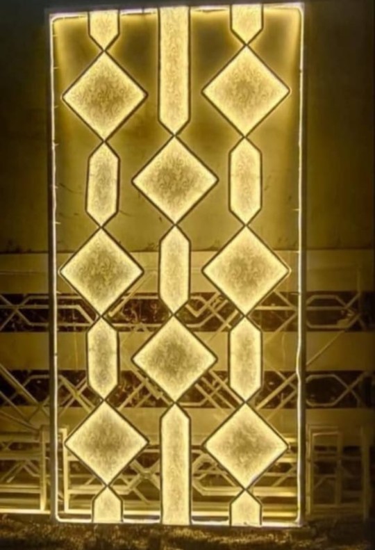Elegant Punjabi wedding decoration featuring a floral stage, golden pillars, hanging flowers, and warm lighting.