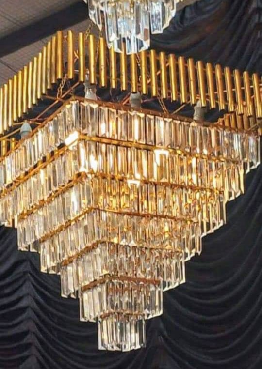 Traditional Punjabi wedding decoration with red and gold floral arrangements, an ornate stage backdrop, and elegant hanging ornaments.